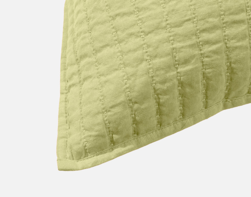 Close-up on the light flanged edge on the corner of our Linen Cotton Square Cushion Cover in Green.