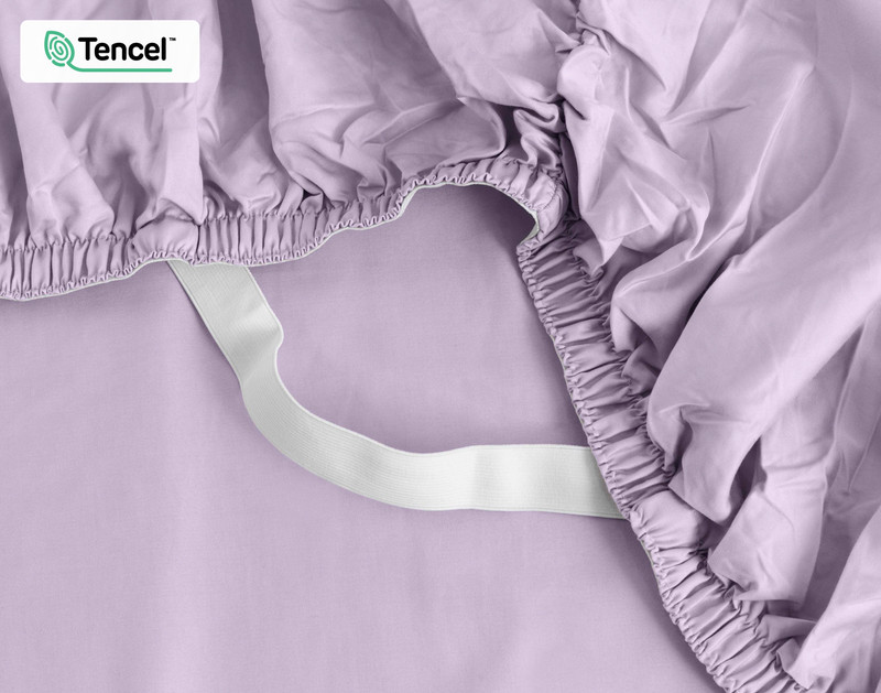 Close-up on the elastic snug fit band on the corner of our Eucalyptus Luxe TENCEL™ Lyocell Fitted Sheet in Lilac.