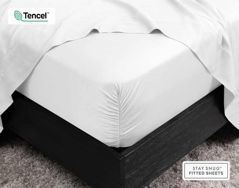 Gros plan sur le coin de notre BeechBliss TENCEL™ Modal Fitted drap en blanc qui s'adapte parfaitement à un matelas avec un drap plat drapé sur le dessus.