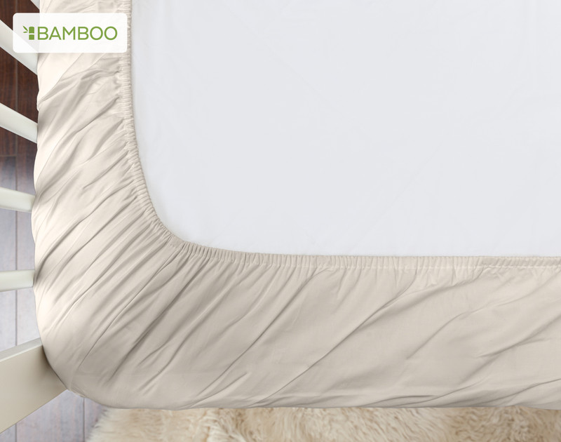 Vue du bas de notre Bamboo Cotton Crib-Sized Fitted drap en Driftwood pour montrer son bord élastique.