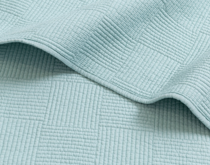 Bord replié sur notre Kenzie Cotton courtepointe ensemble  en Fountain Blue pour montrer sa bordure ourlée.