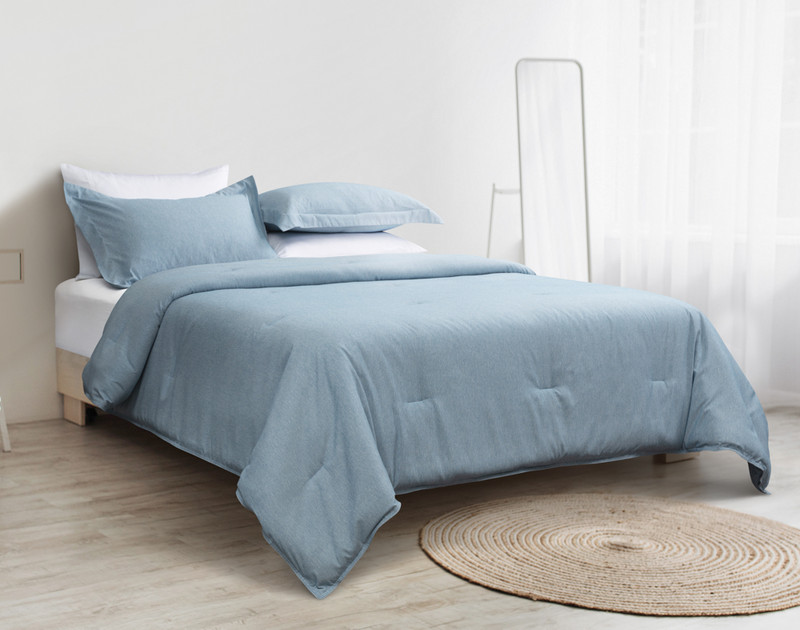Our Heathered Jacquard Comforter Set in Steel Blue dressed over a queen bed in a minimalist white bedroom.