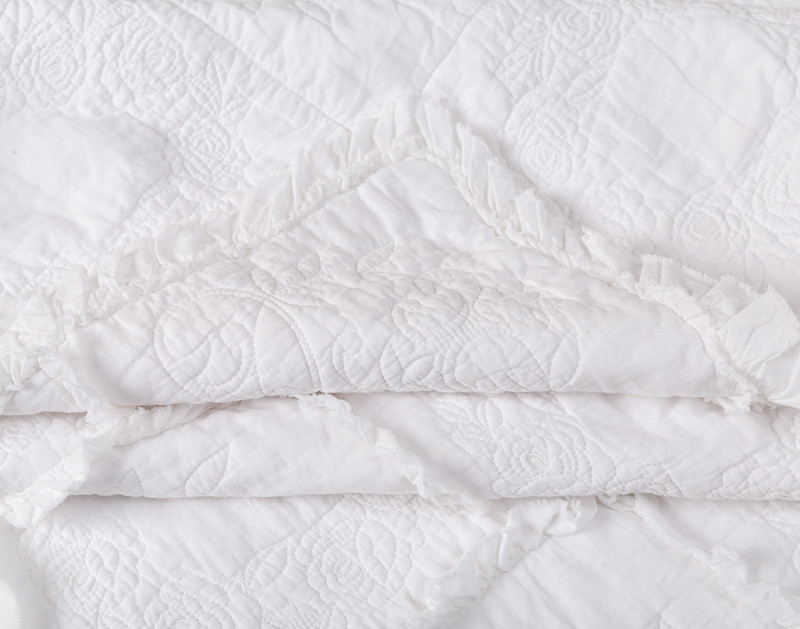 Folded corner on our Rosalie Crib-Sized Cotton Quilt to show its soft and flexible cotton softness.