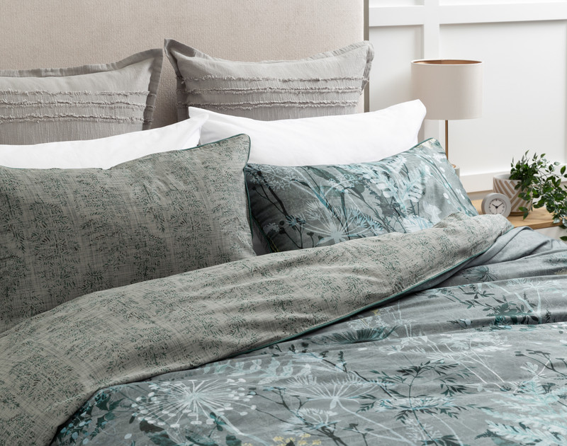 Angled view of our Thistledown Duvet Cover with reversed pillow shams, slightly unmade.