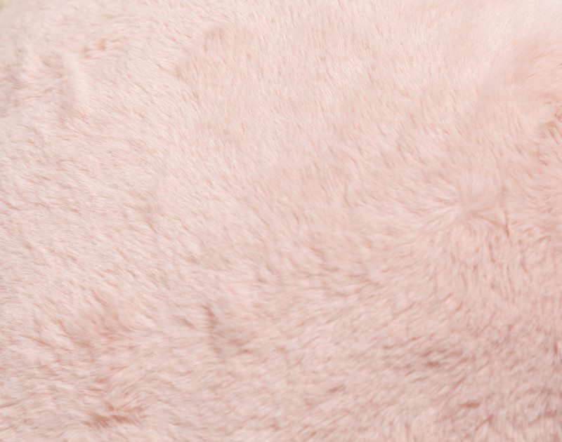 Gros plan sur la texture pelucheuse très douce de notre coussin rose Heart Cushion.