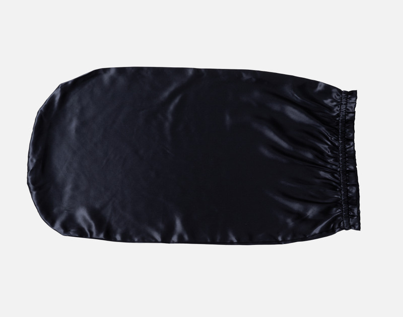 Top view of our Mulberry Silk Sleep Cap in Black sitting empty against a solid white background.