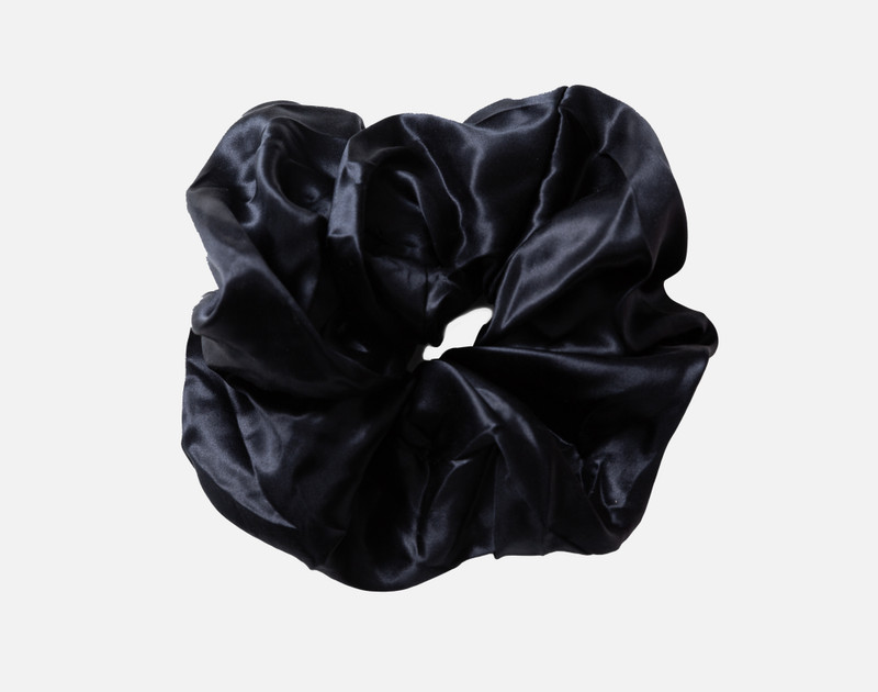 Top view of our Mulberry Silk Oversized Scrunchie in Black sitting against a solid white background.