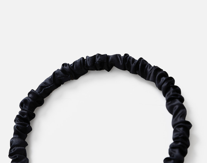 Close-up on the ruched top edge of our Mulberry Silk Wrapped Hairband in Black.
