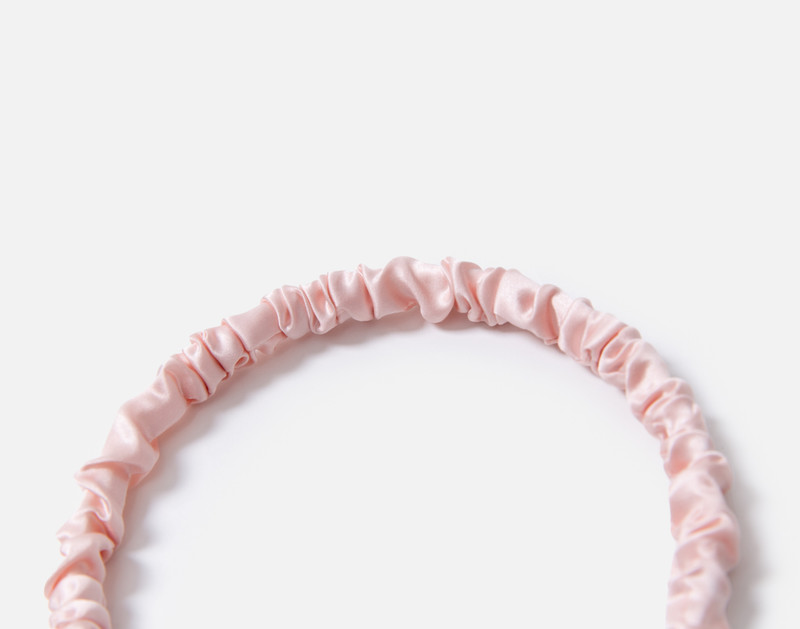 Close-up on the ruched top edge of our Mulberry Silk Wrapped Hairband in Blush.