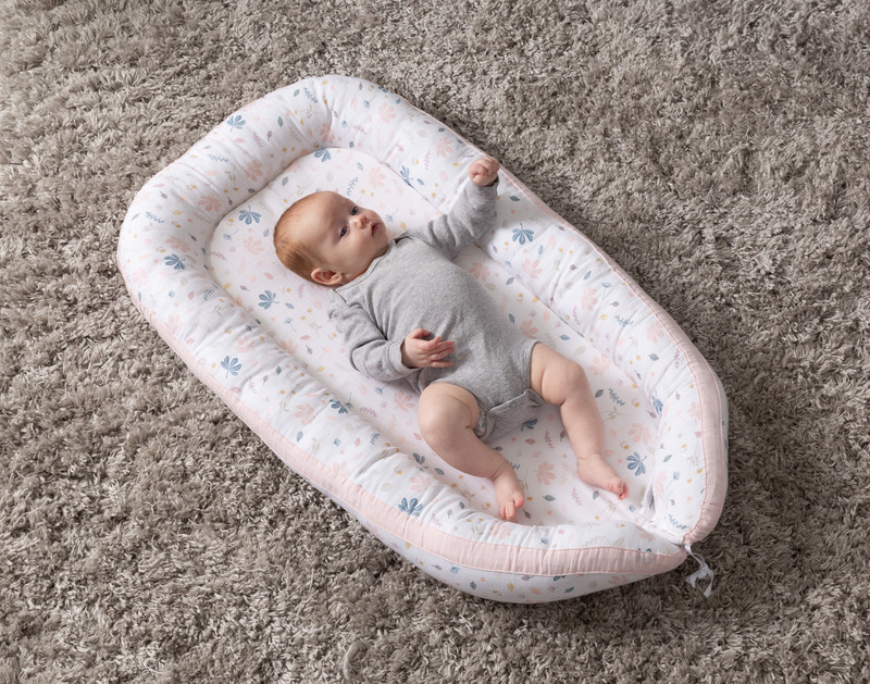 Top view of our Baby Nest Bed in Blush with a baby