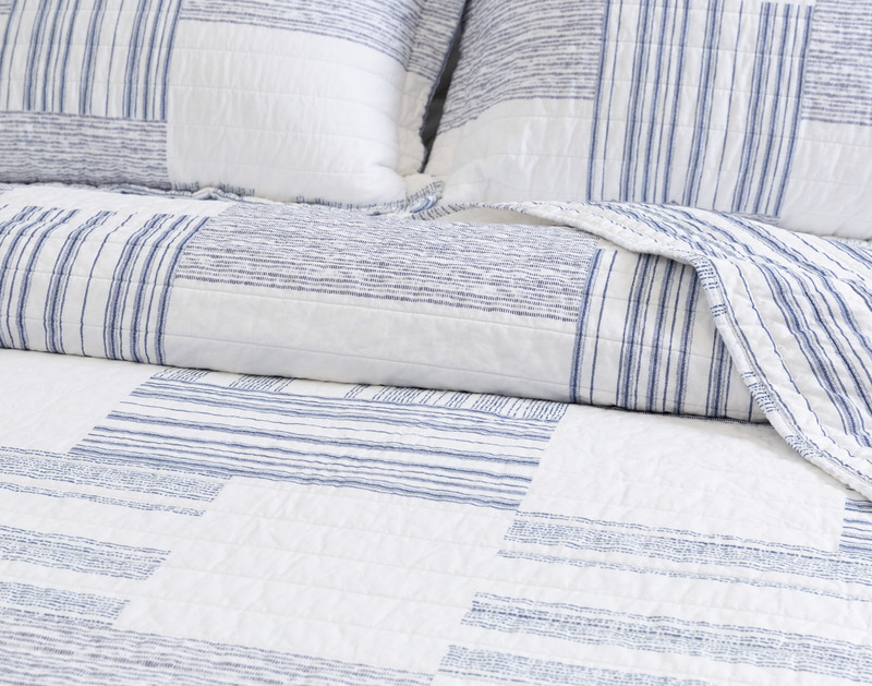 Angled view of the surface on our Frankie Cotton Quilt Set to show its alternating striped patterns.