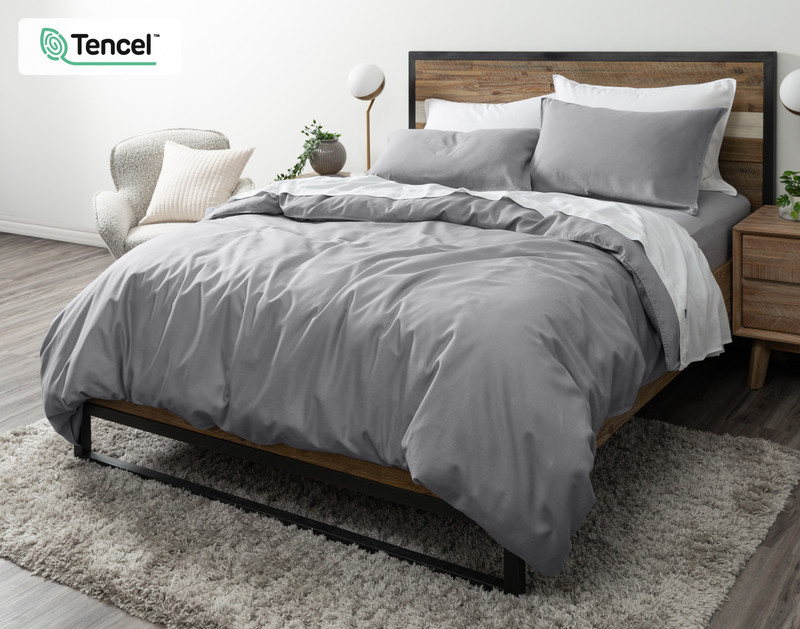 Angled view of our Hemp Touch Duvet Cover in Grey draped over a queen bed with coordinating white sheets and pillowcases.