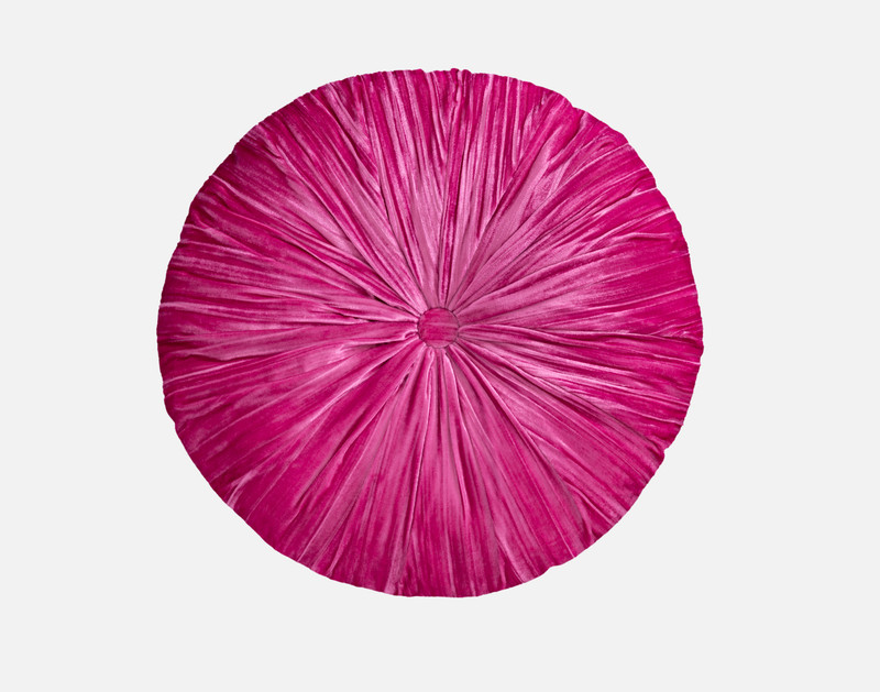 Vue de dessus de notre coussin rond Sulani pour montrer sa surface fuchsia chatoyante sur un fond blanc uni.