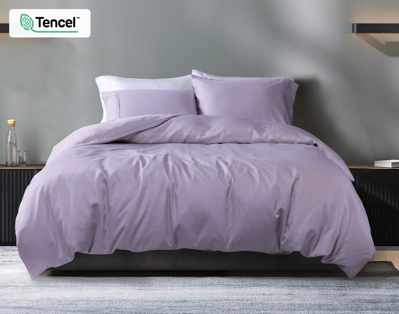 Vue de face de notre housse de couette Eucalyptus Luxe TENCEL™ Lyocell en Lilas habillée sur un lit queen avec du gris draps dans une chambre moderne blanche.