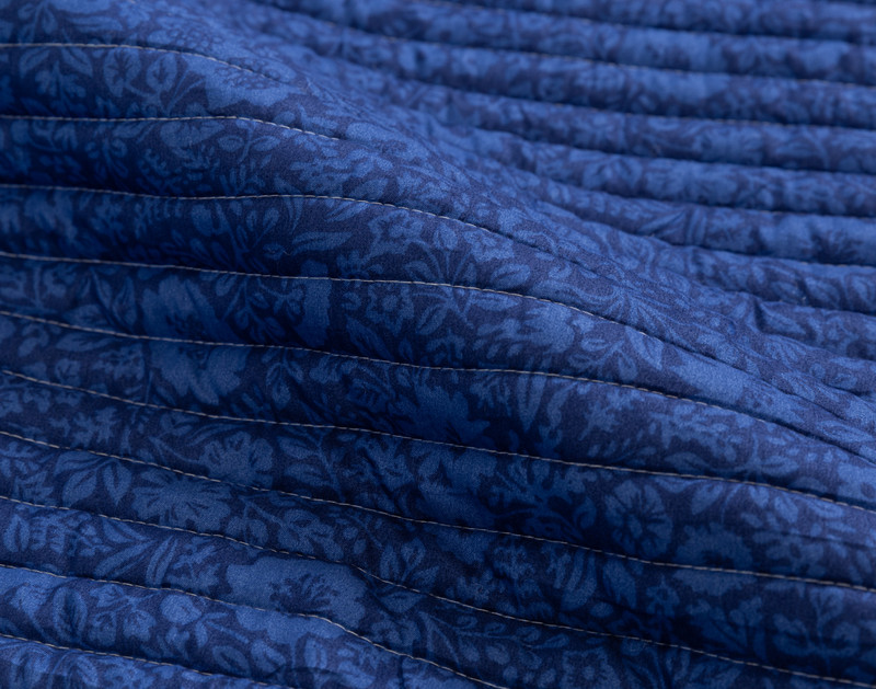 Close-up on the horizontal stitching and blue floral print on the reverse side of our Blue Willow Coverlet Set.