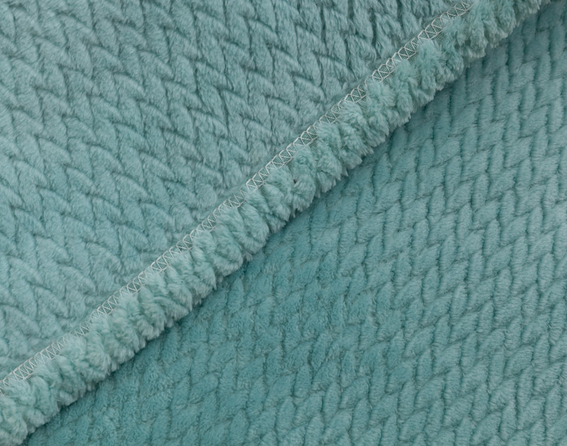 Close-up on the hemmed border on our Chevron Plush Throw in Aqua to show its matching reverse and front together.
