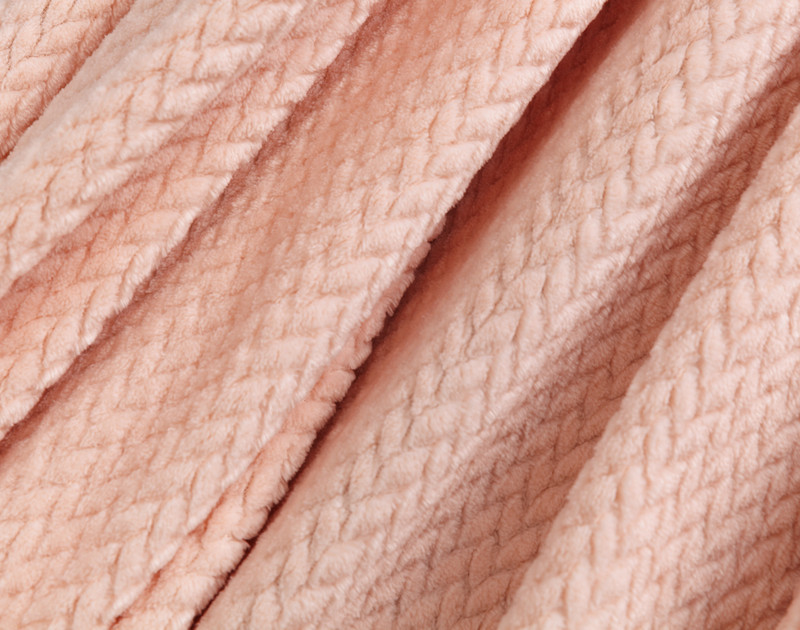 Gros plan sur le tissu à volants de notre peluche Chevron Jeté en rose blush pour montrer sa surface douce.