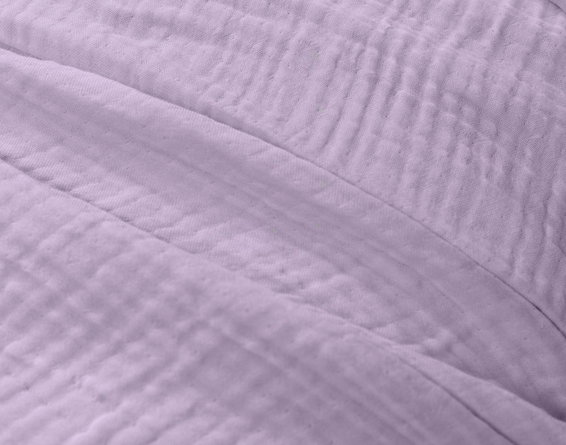 Close-up on our Muslin Gauze Throw in Violet to show its subtle grid-like texture and cozy cotton and lyocell surface.