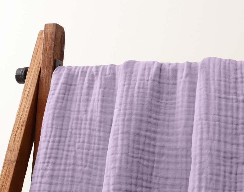 Close-up of our Muslin Gauze Throw in Violet hanging to show its soft drape.