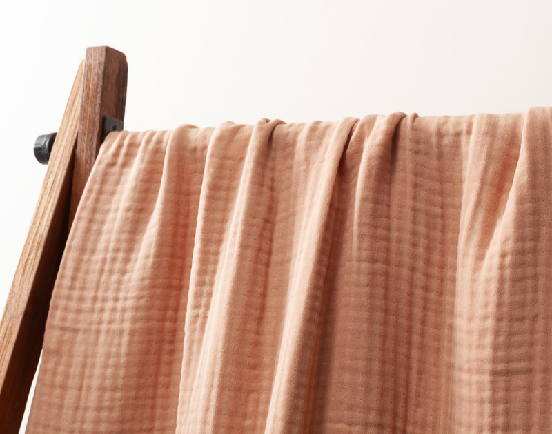 Close-up of our Muslin Gauze Throw in Clay hanging to show its soft drape.