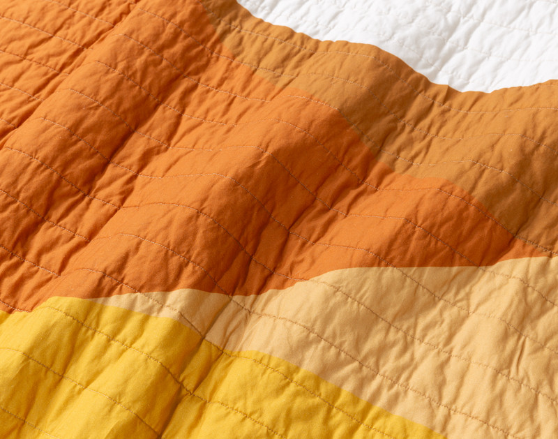 Close-up on the stitching and mixed colours on our Golden Hills Cotton Quilt Set.