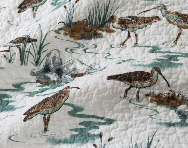 Close-up on the birds and wetlands on the surface design of our Sandpiper Cotton Quilt Set.