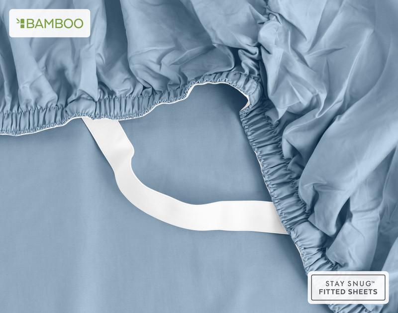 Underside of our Bamboo Cotton Fitted Sheet in Mistral Blue with two hands stretching the snug fit elastic strands around the corner of a mattress.