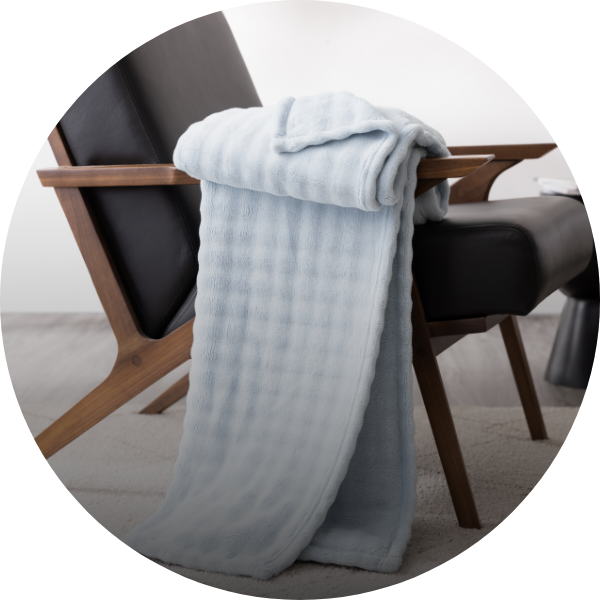 Draped throw blanket in light blue over a couch.