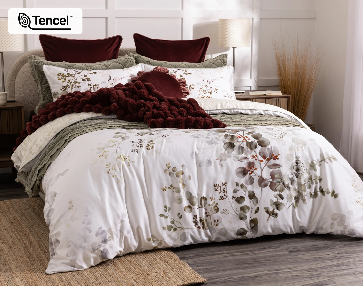 Angled view of our Sasha Duvet Cover dressed over a queen bed with coordinating red and green accessories.
