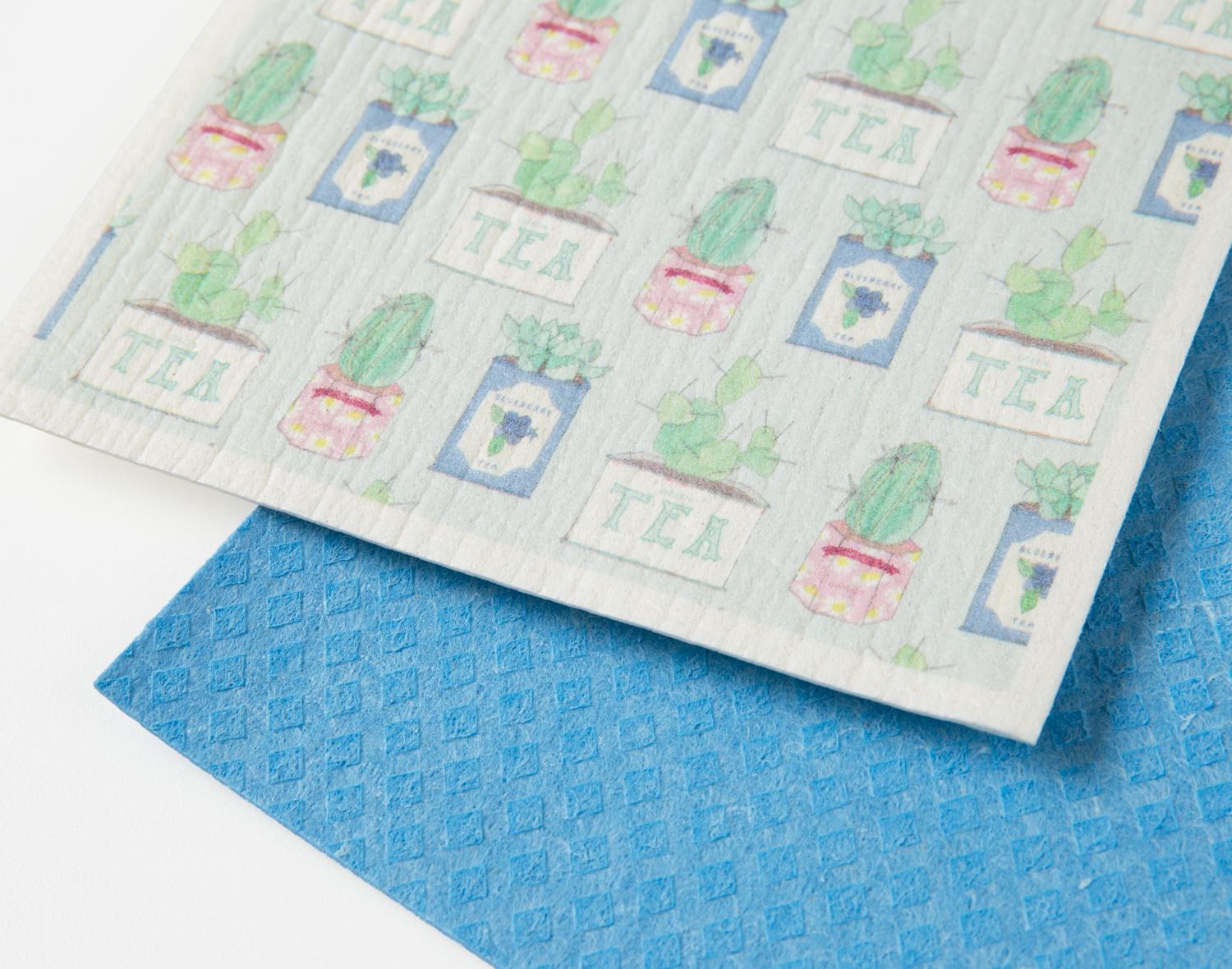Close view of our Tea Tins Swedish Dishcloth Set resting on a solid white ground.