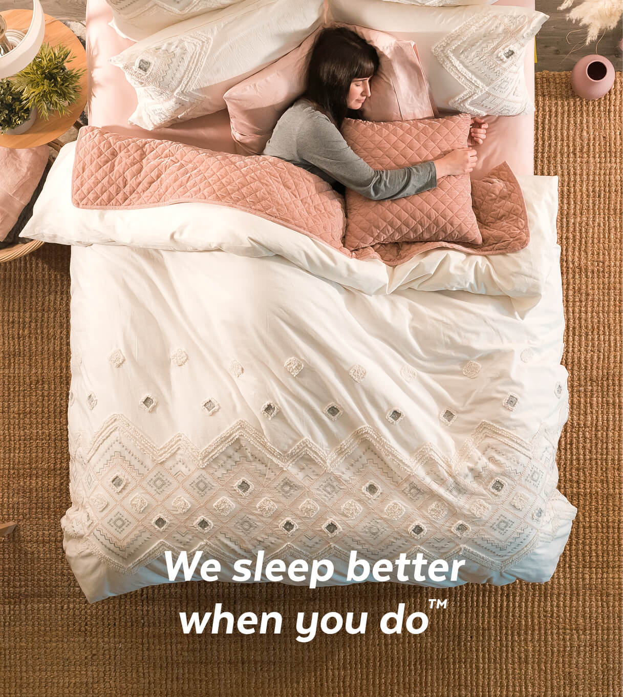 Woman sleeping in Charity Bedding Collection with text overlay that says 'We sleep better when you do'
