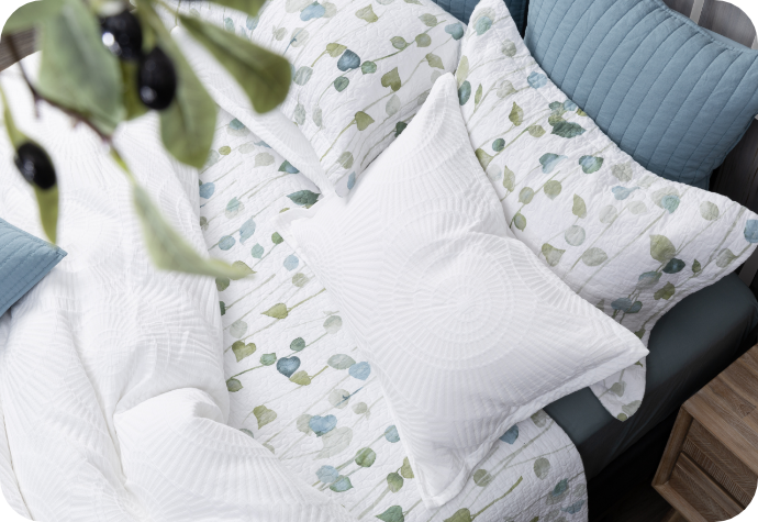 The Boca Duvet Cover and matching pillow shams dressing a queen bed along with a botanical coverlet set.