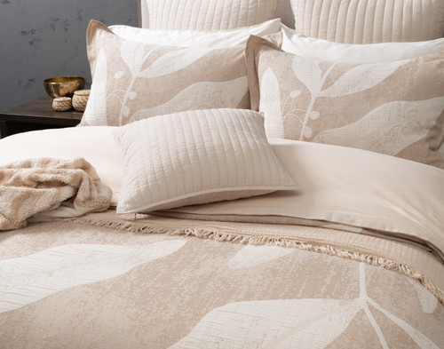 Angled view of our Natura Duvet Cover with cushions and throws draped overtop.