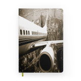 Departing Aircraft & City Scene behind Designed Notebooks