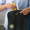 A black neoprene stubby cooler bag being held, with a bottle being inserted into it. The bag has a logo.