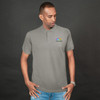 A grey polo shirt worn by a man, featuring a small logo on the chest. The background is dark.