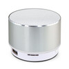 A silver Bluetooth speaker with a textured top and a white base, featuring a subtle logo.