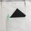 A black notebook and green pen are visible in a front pocket of a white cooler bag. The bag features a zippered closure.