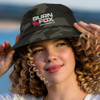 A camouflage bucket hat with a logo, featuring shades of green and black, worn by a young woman with curly hair.
