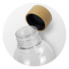 A drink bottle with a clear body and a natural bamboo lid on top, featuring a black inner cap.