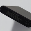 A black power bank with a sleek design, featuring various input and output specifications on the surface.