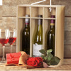 A wooden wine gift box in natural colour holding three bottles of wine, accompanied by glasses, a gift box, and a rose.