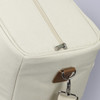 A cream-coloured cooler tote bag with a zippered closure and a leather accent. It features a metal clip.