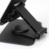 A black metal phone and tablet stand with an adjustable support arm and a circular base. It features a logo.