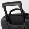 A close-up of a black wheeled suitcase handle, featuring a textured surface and a retractable mechanism.