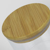 A large round storage canister with a clear glass body and a bamboo lid. Features a logo on the side.