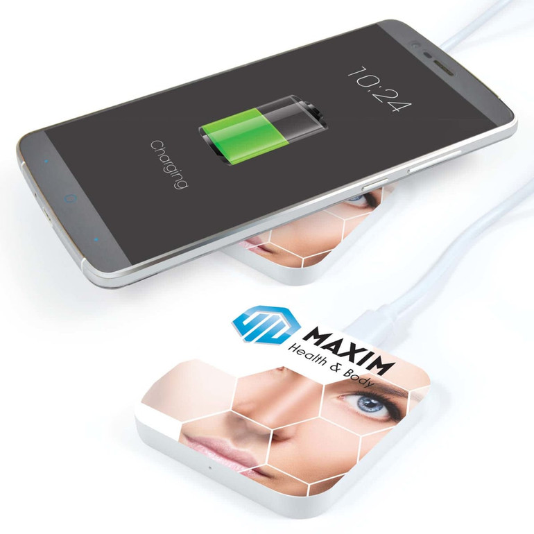 A white wireless charger with a design featuring a face, placed under a smartphone displaying a charging icon.