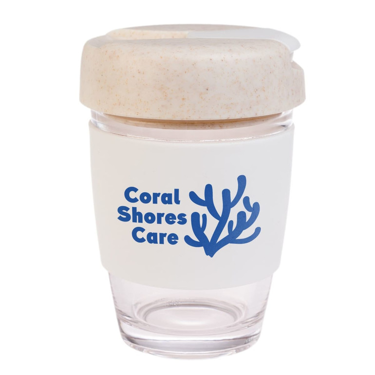 A reusable coffee cup in clear with a white silicone band and a natural-colored lid, featuring a logo.