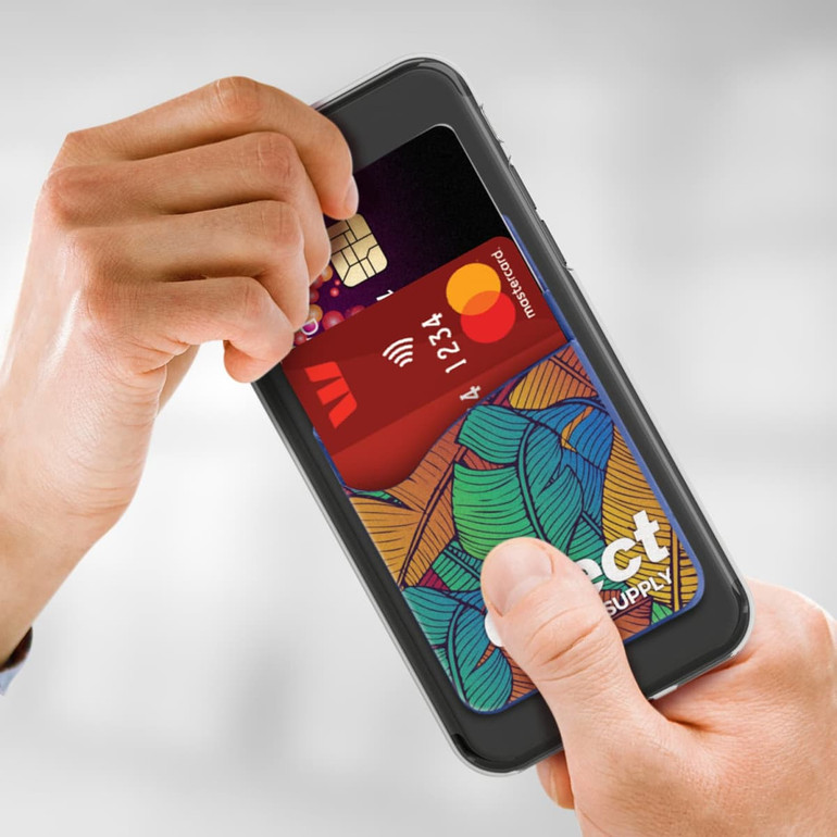 A person inserting cards into a full-colour dual silicone phone wallet attached to a smartphone.