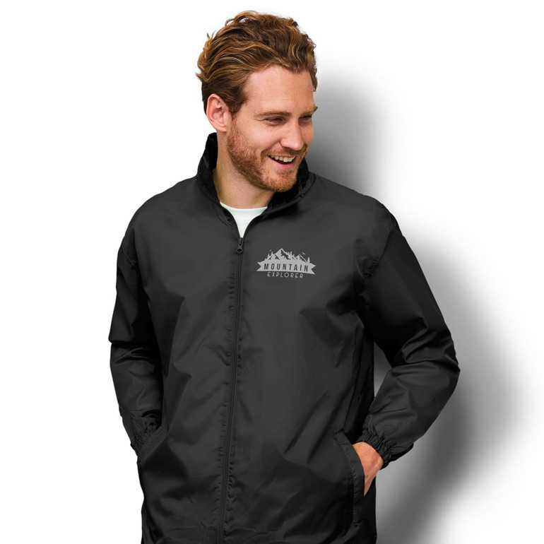 A black windbreaker jacket featuring a logo on the front, with a smiling man wearing it.